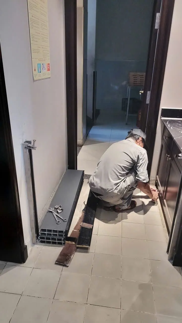 Kỹ thuật viên lắp trụ vách ngăn chống ngập ở hành lang